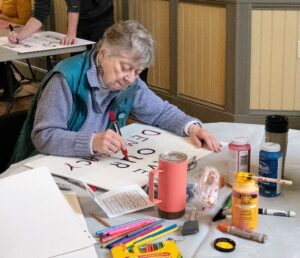 Scores gather to make signs for big April 5 protest