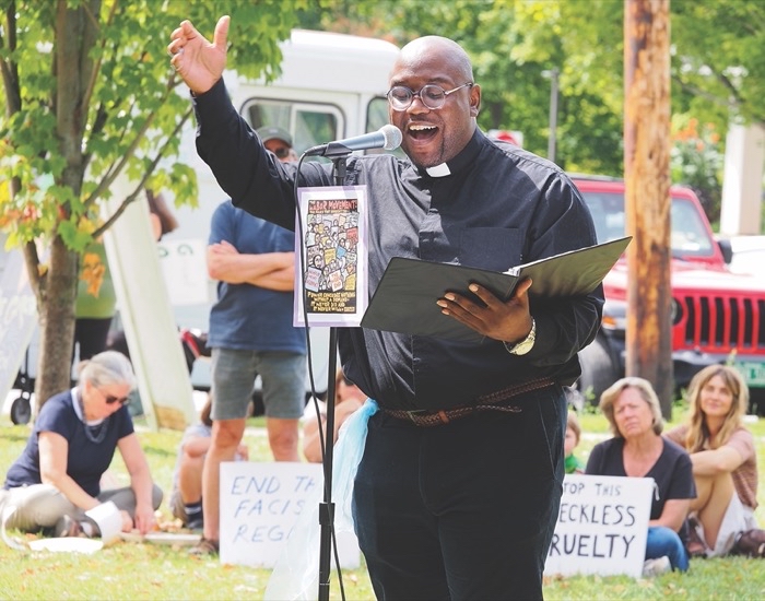 A pastor enthusiastically speaks to a crowd of protestors